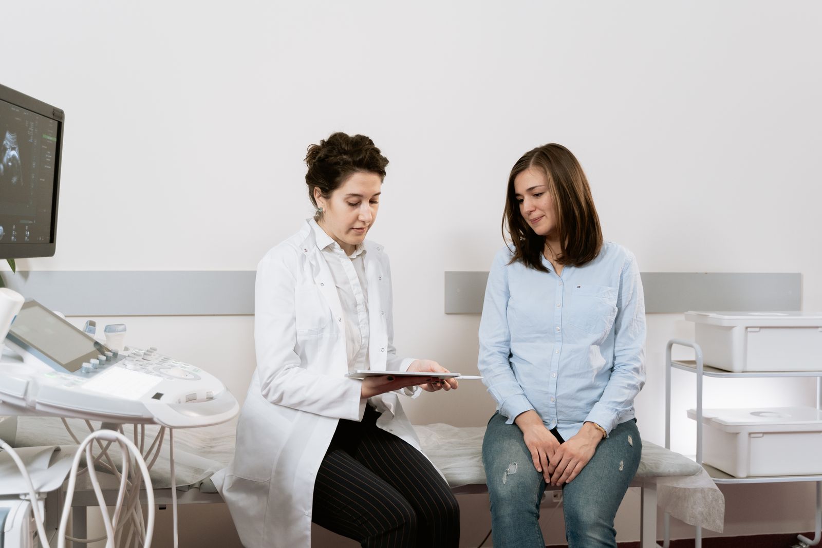 Pregnant person speaking with a clinician in a medical office